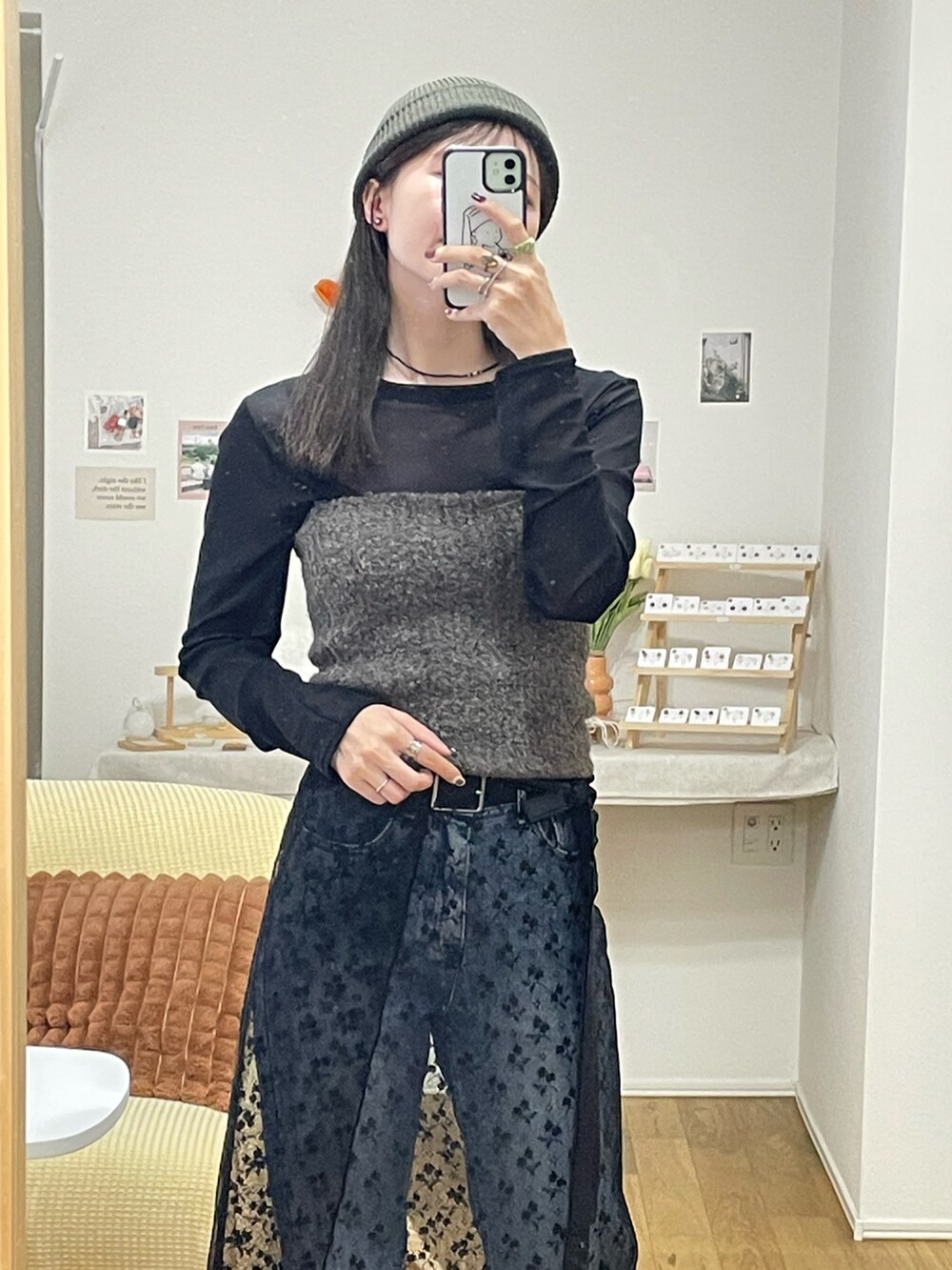 ブラウン系のニット/セーター、ブラック系のスカート、ブルー系のデニムパンツを着用したレディースの秋コーディネートの3枚目の写真