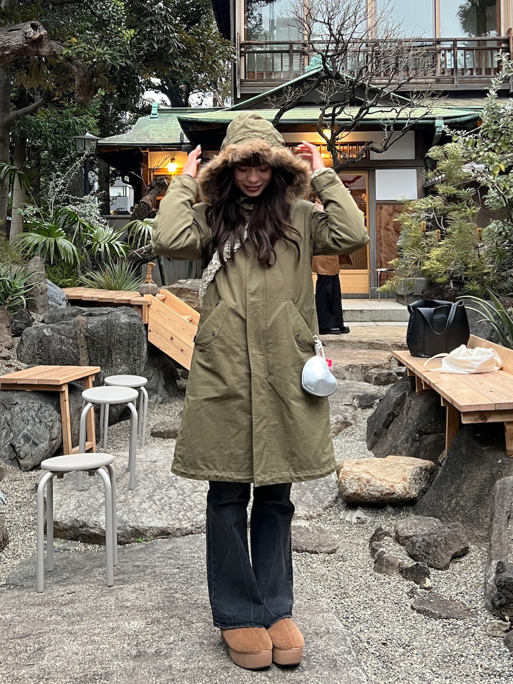 ブラック系のデニムパンツ、グリーン系のモッズコート、ベージュ系のブーツを着用したレディースの冬コーディネートの2枚目の写真