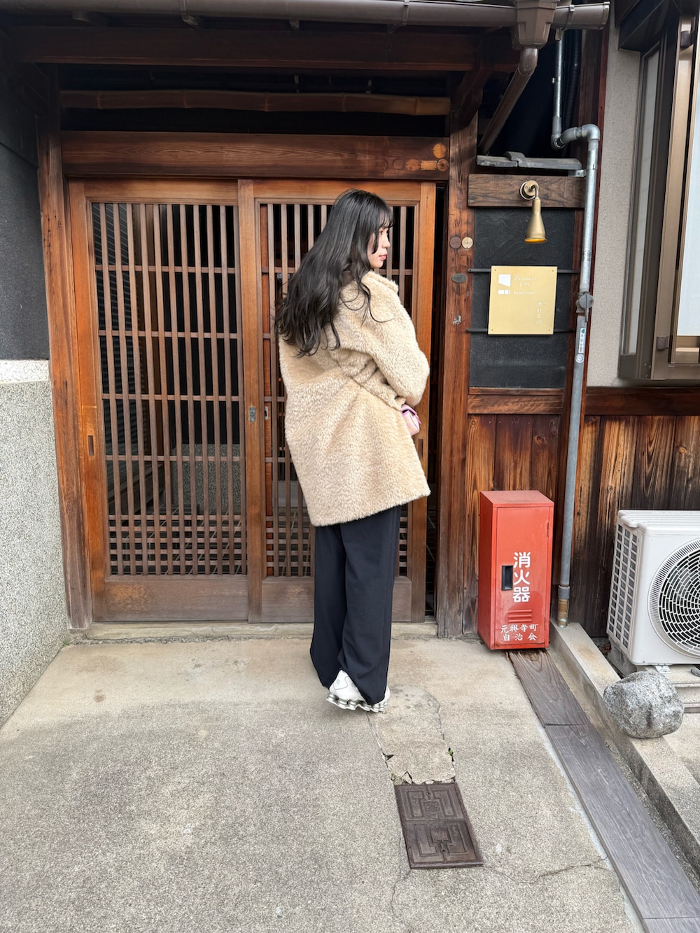 ベージュ系のその他アウター、ピンク系のショルダーバッグ、ブルー系のスラックスを着用したレディースの冬コーディネートの3枚目の写真