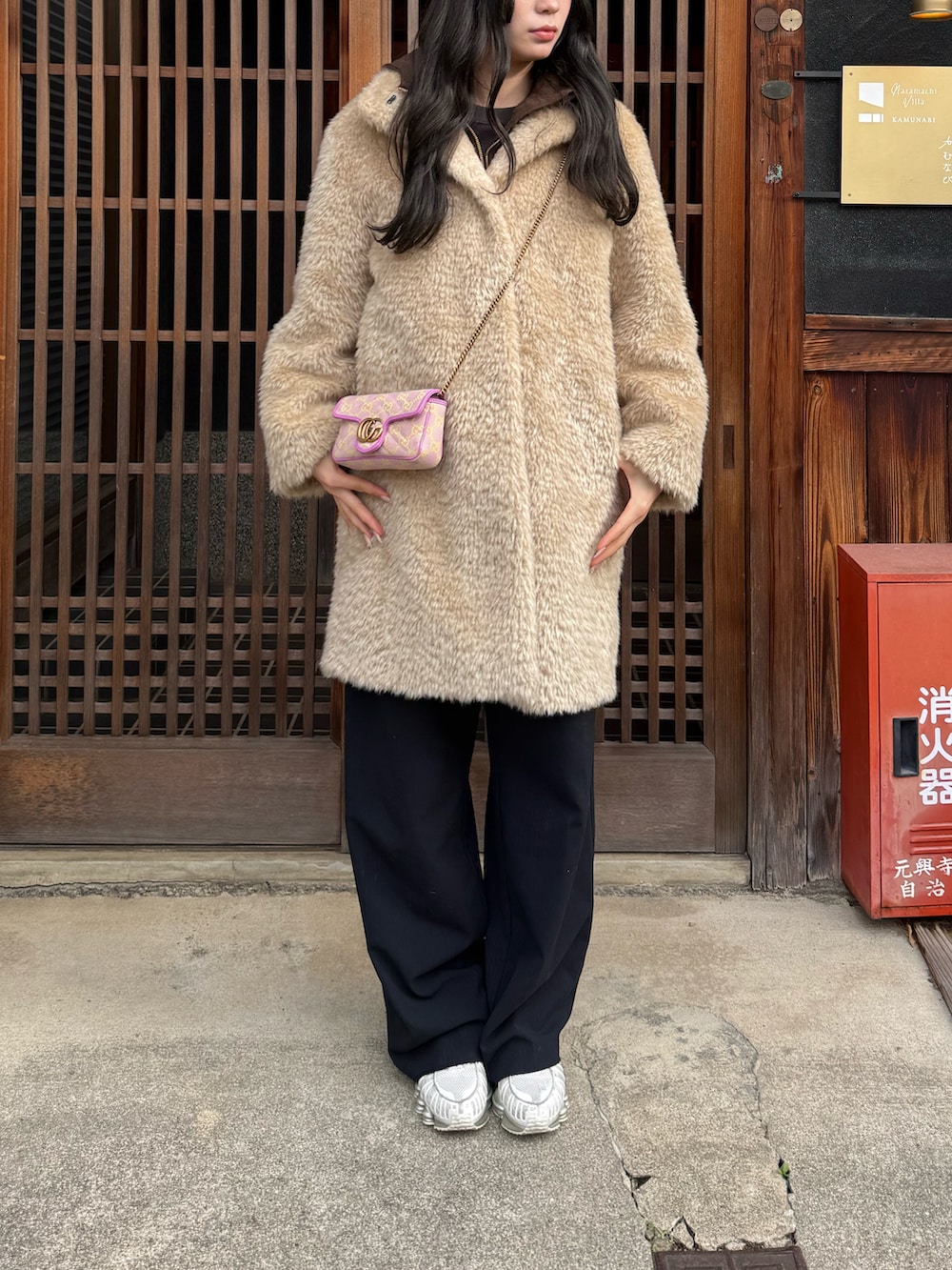 ベージュ系のその他アウター、ピンク系のショルダーバッグ、ブルー系のスラックスを着用したレディースの冬コーディネートの2枚目の写真