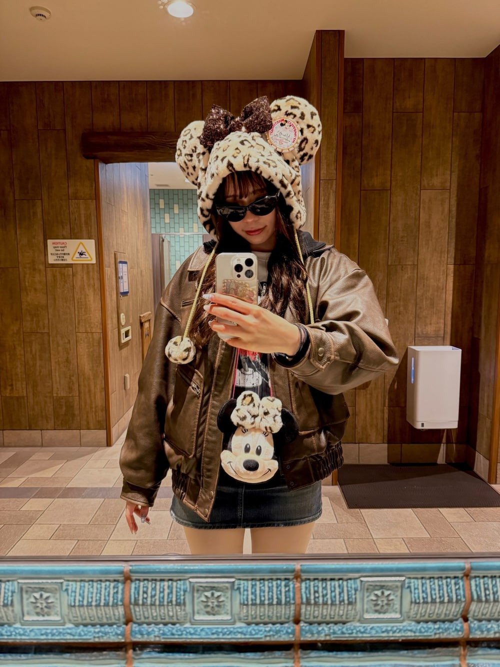 ブラウン系のライダースジャケット、ブルー系のデニムスカートを着用したレディースの冬コーディネートの2枚目の写真