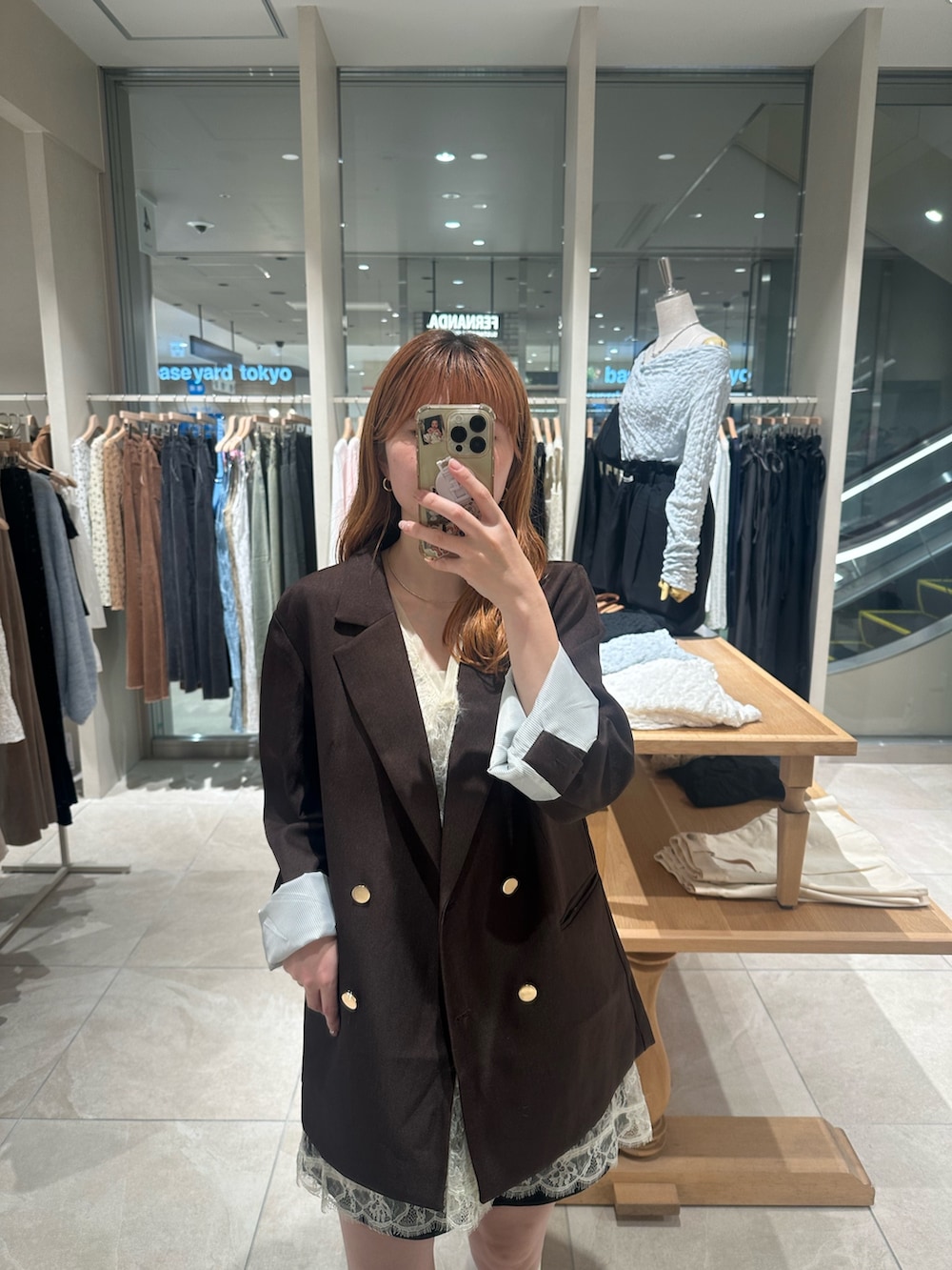 ブラウン系のテーラードジャケット、ホワイト系のキャミソール、ホワイト系のタンクトップを着用したレディースの秋コーディネートの2枚目の写真