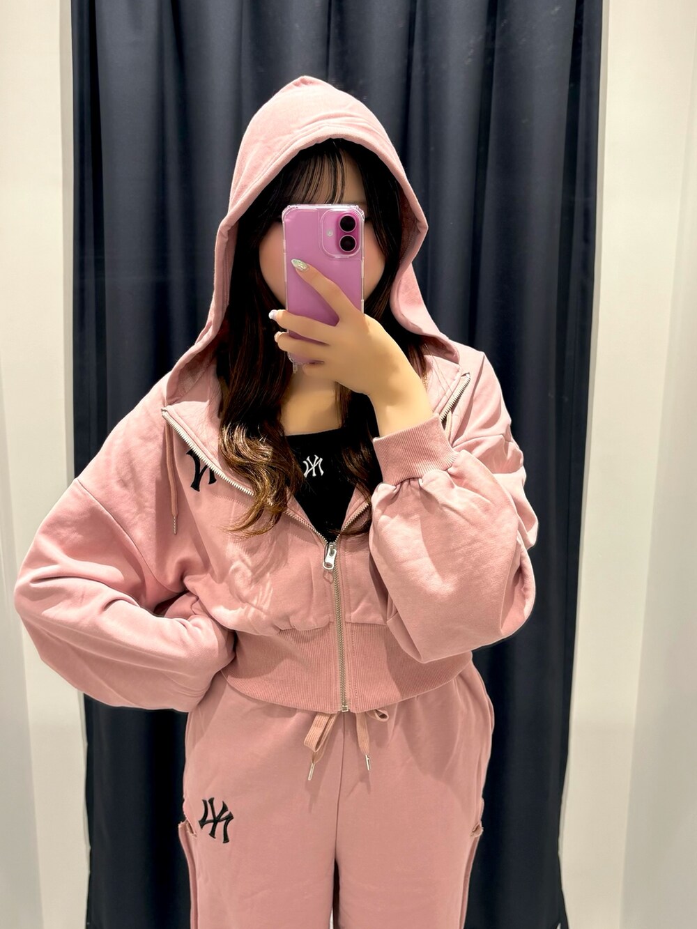 ピンク系のスウェットパンツ、ピンク系のパーカー、ブラック系のキャミソールを着用したレディースの夏コーディネートの2枚目の写真