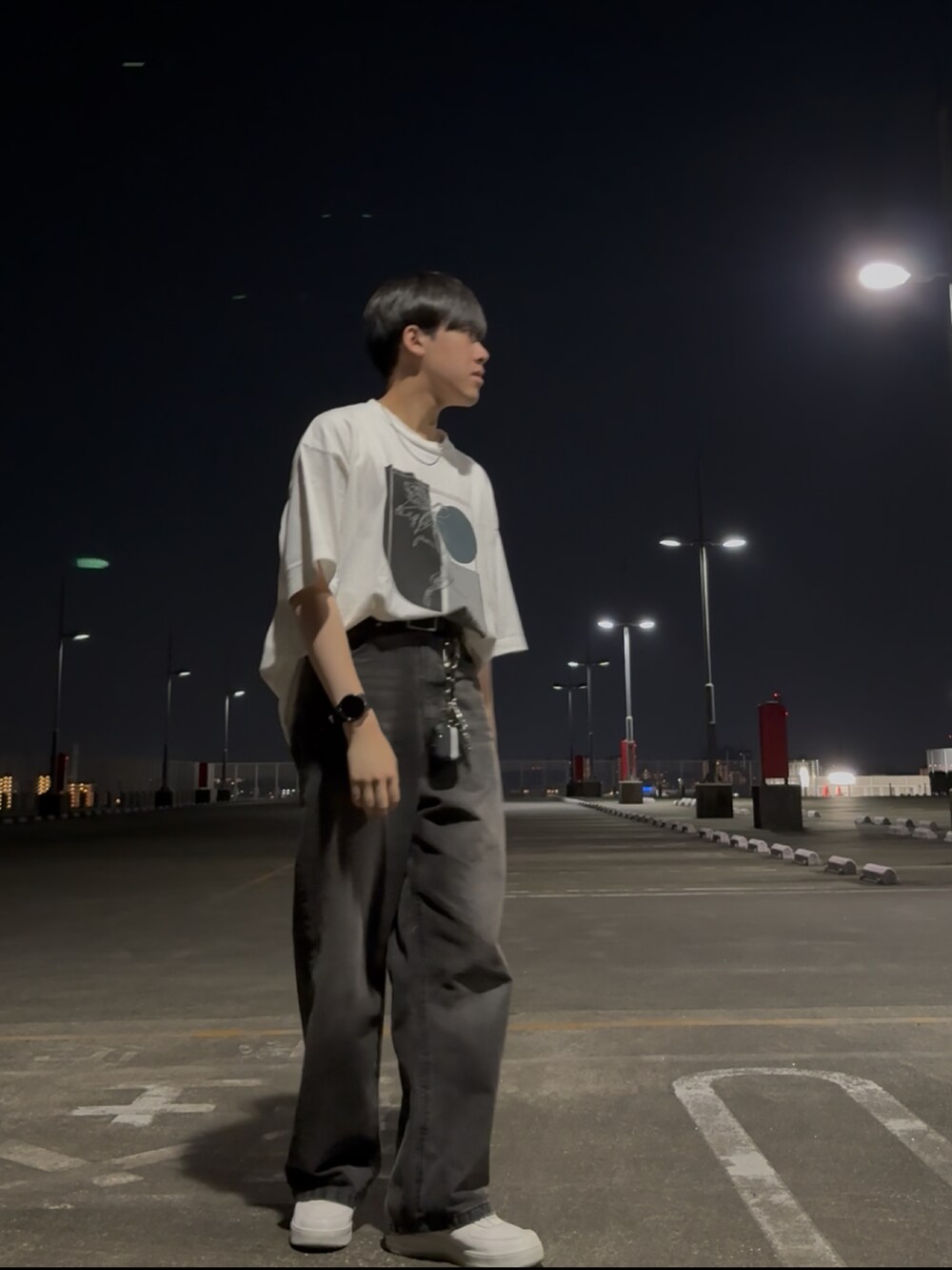 ホワイト系のTシャツ/カットソー、ブラック系のデニムパンツ、ホワイト系のスニーカーを着用したメンズの春コーディネートの2枚目の写真
