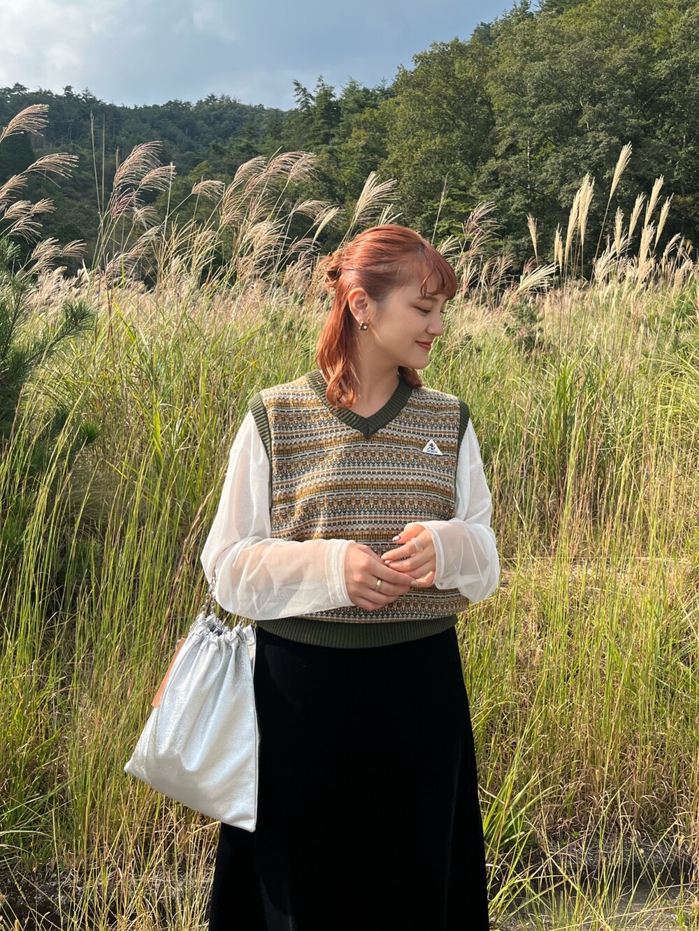 グリーン系のベストを着用したレディースの冬コーディネートの3枚目の写真