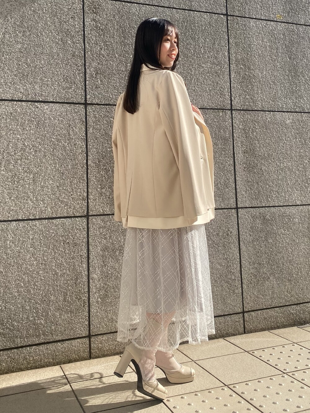 ブルー系のワンピース、ホワイト系のテーラードジャケットを着用したレディースの冬コーディネートの3枚目の写真