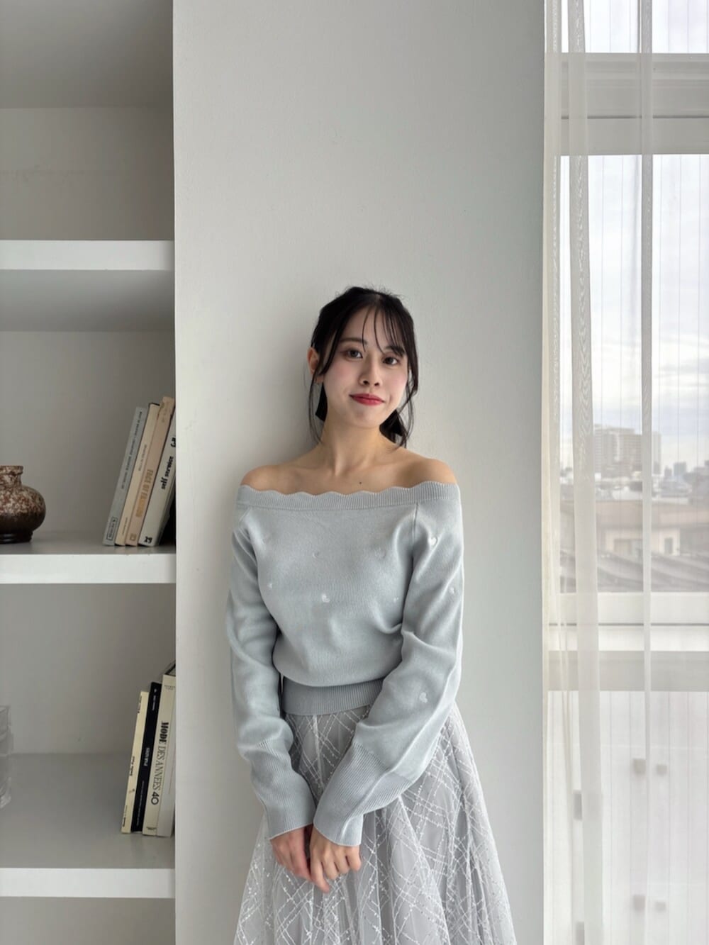 ホワイト系のパンプス、グリーン系のニット/セーター、グレー系のスカートを着用したレディースの冬コーディネートの9枚目の写真