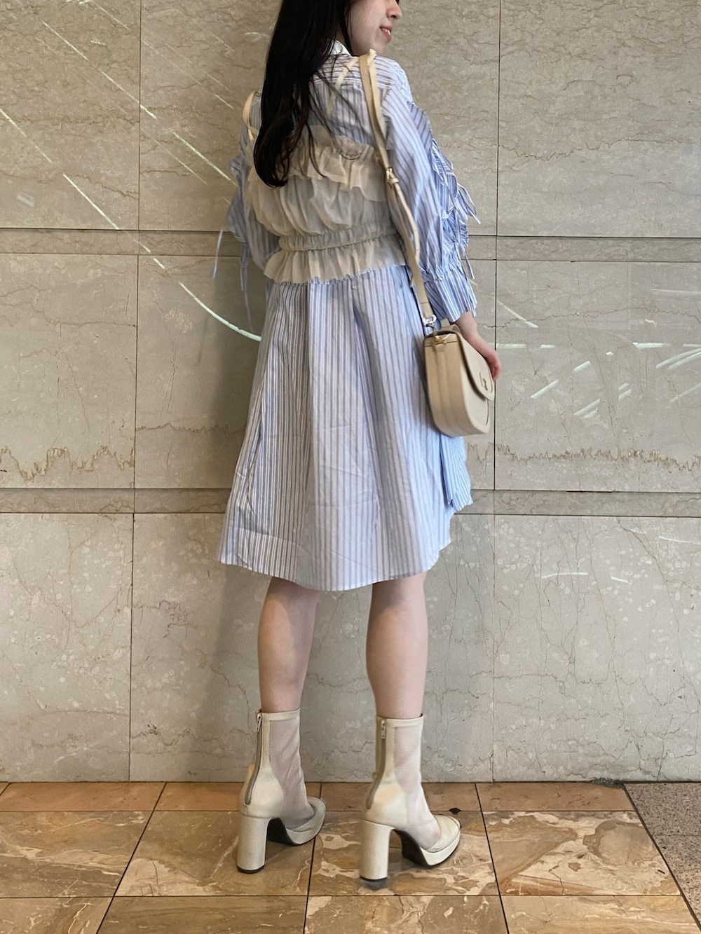 ブルー系のシャツワンピース、ホワイト系のハンドバッグを着用したレディースの夏コーディネートの5枚目の写真