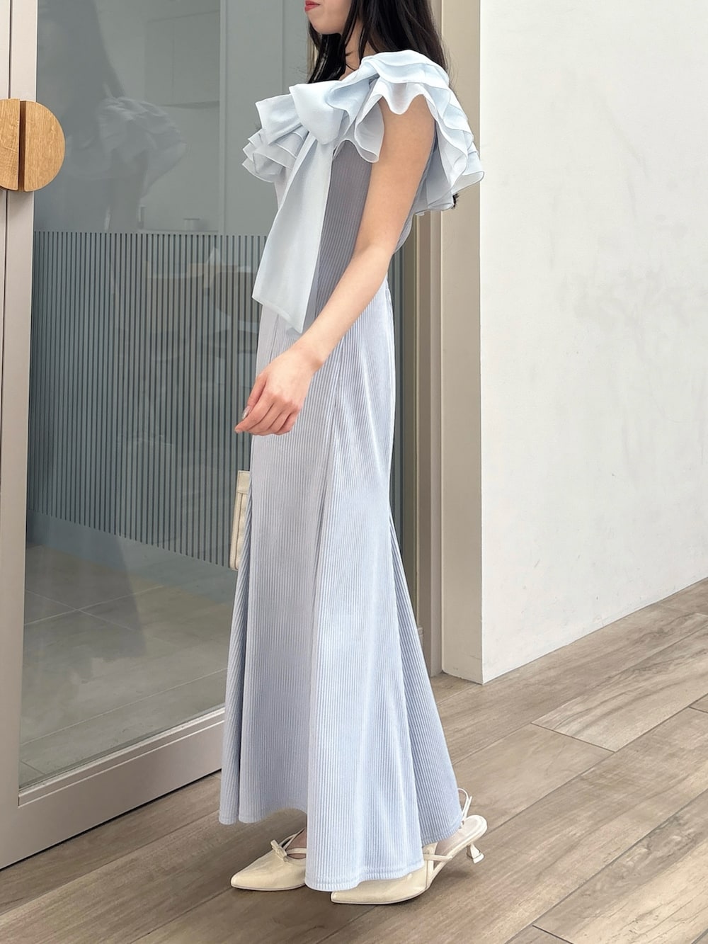 ブルー系のワンピース、ホワイト系のパンプス、ホワイト系のハンドバッグを着用したレディースの春コーディネートの3枚目の写真