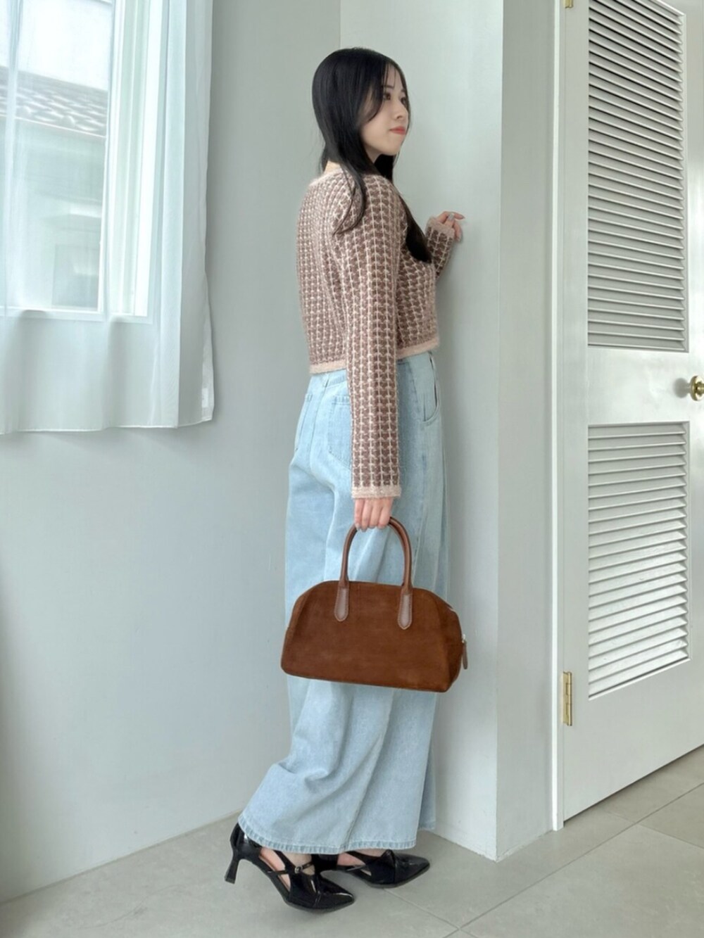 ブルー系のデニムパンツ、ブラウン系のカーディガン/ボレロを着用したレディースの秋コーディネートの3枚目の写真