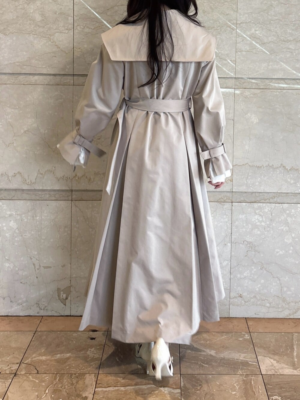 ホワイト系のパンプス、ベージュ系のトレンチコートを着用したレディースの冬コーディネートの4枚目の写真