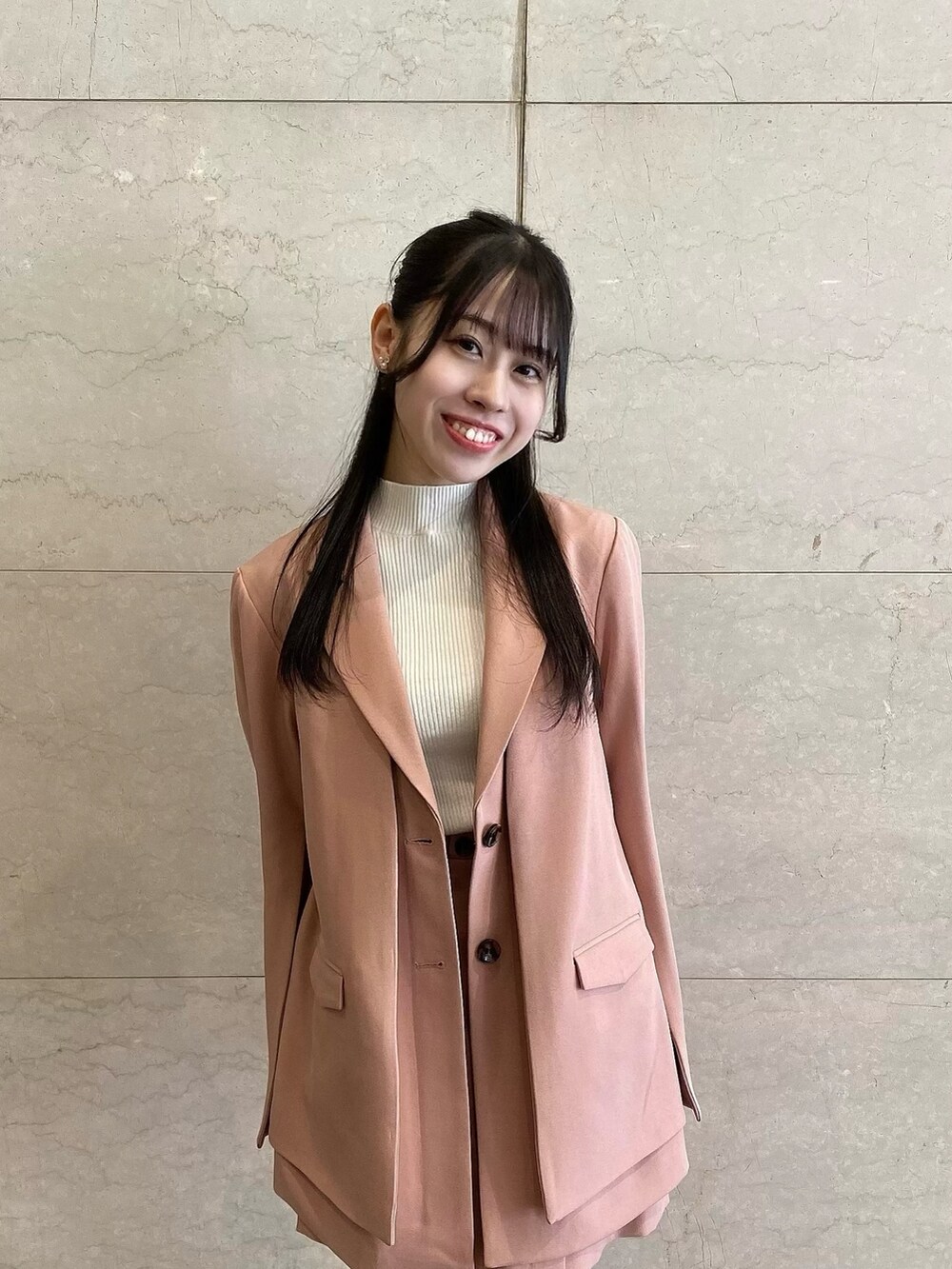 ピンク系のテーラードジャケット、ピンク系のテーラードジャケット、ピンク系のスカートを着用したレディースの冬コーディネートの3枚目の写真