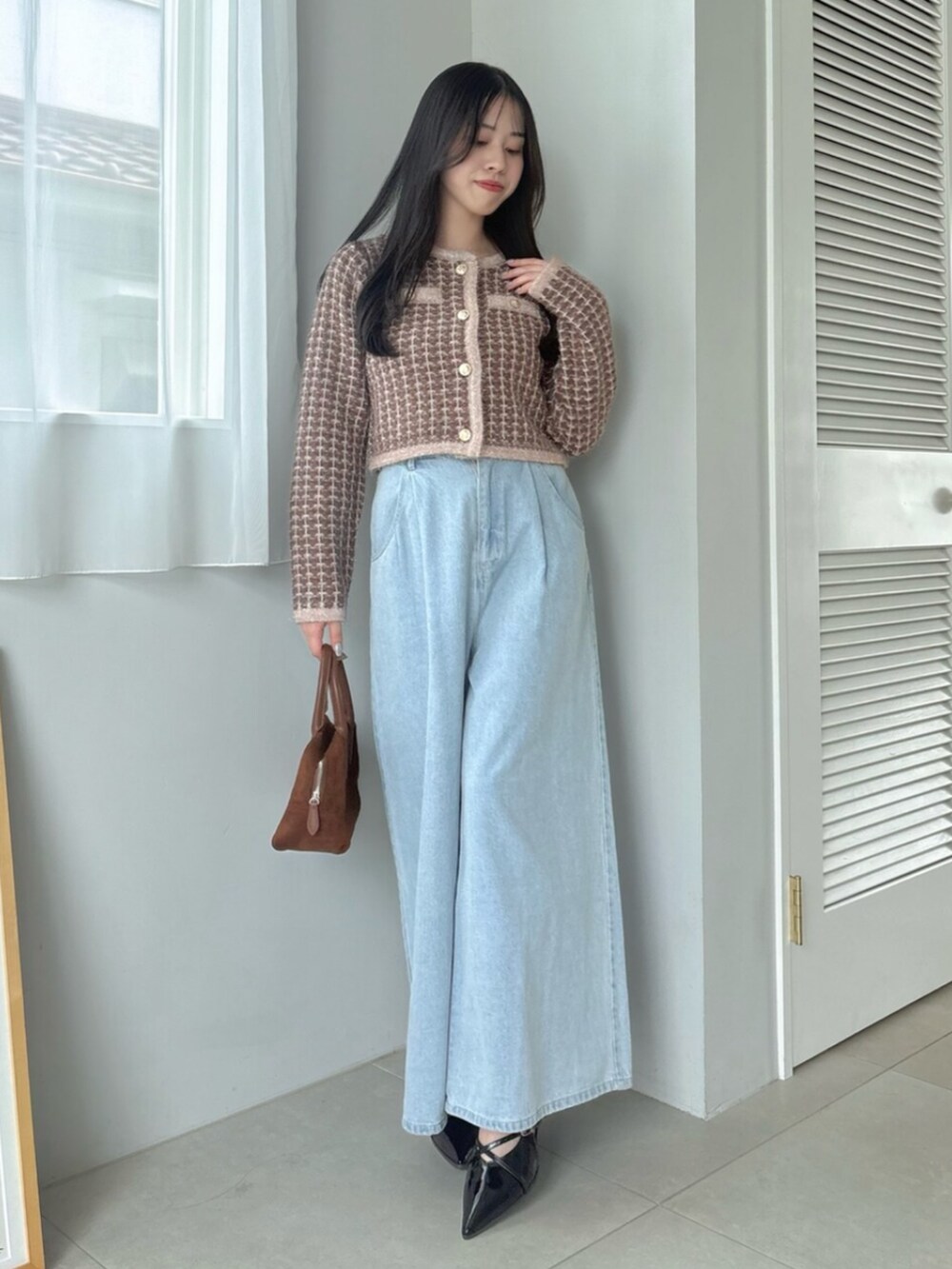 ブルー系のデニムパンツ、ブラウン系のカーディガン/ボレロを着用したレディースの秋コーディネートの2枚目の写真