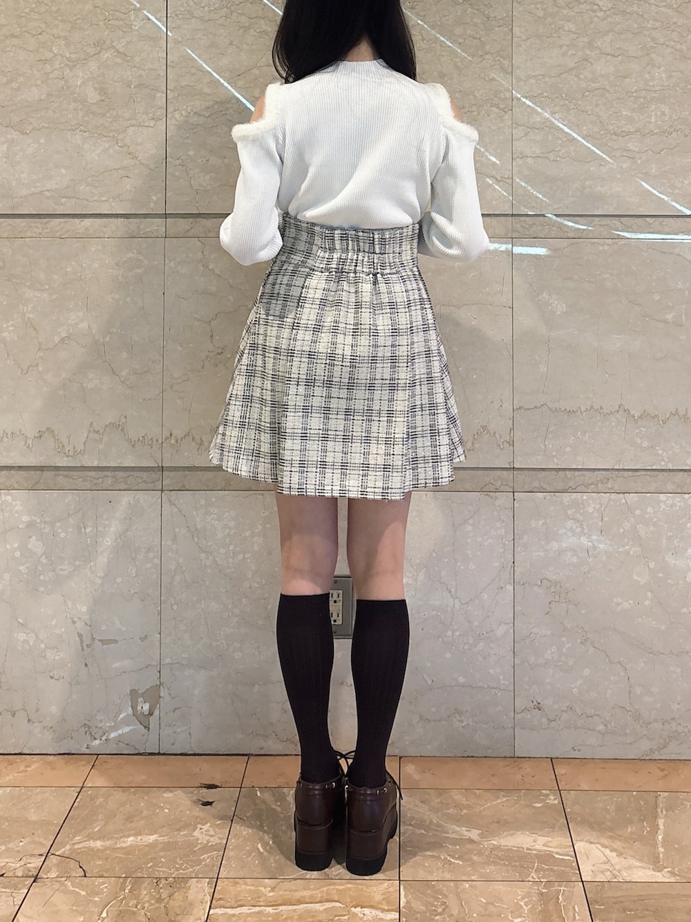 ホワイト系のニット/セーター、ホワイト系のスカート、ブラウン系のローファーを着用したレディースの冬コーディネートの6枚目の写真