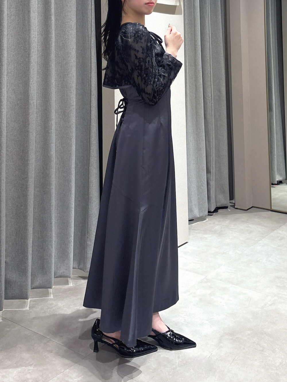 ブラック系のドレス、ブラック系のパンプスを着用したレディースの冬コーディネートの6枚目の写真