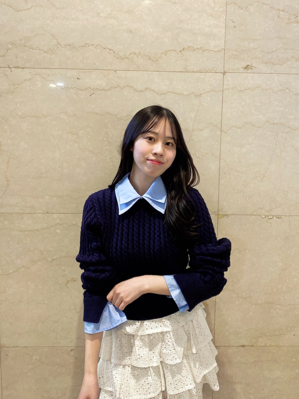 ホワイト系のスカート、ブルー系のニット/セーターを着用したレディースの春コーディネートの5枚目の写真