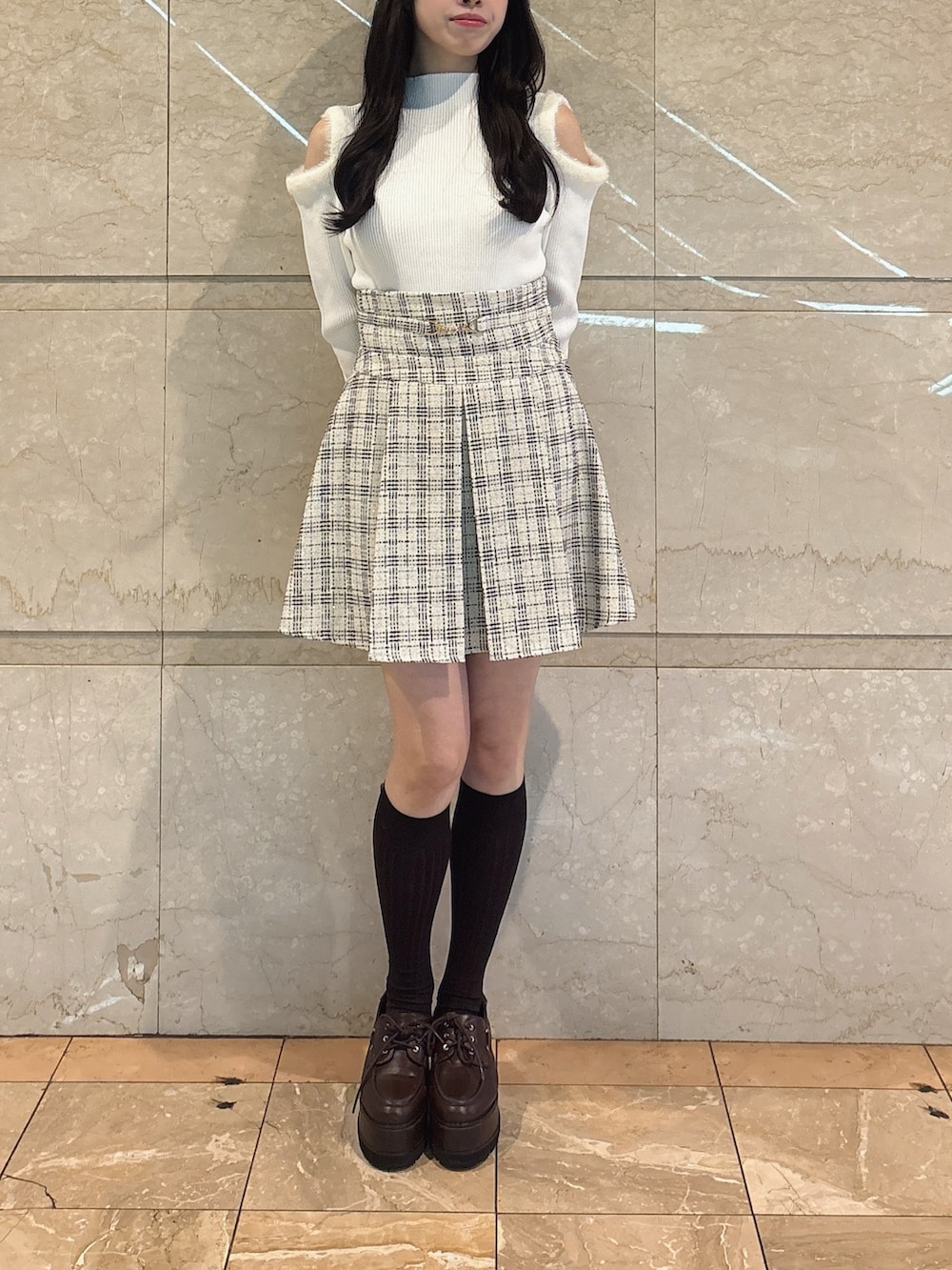 ホワイト系のニット/セーター、ホワイト系のスカート、ブラウン系のローファーを着用したレディースの冬コーディネートの4枚目の写真