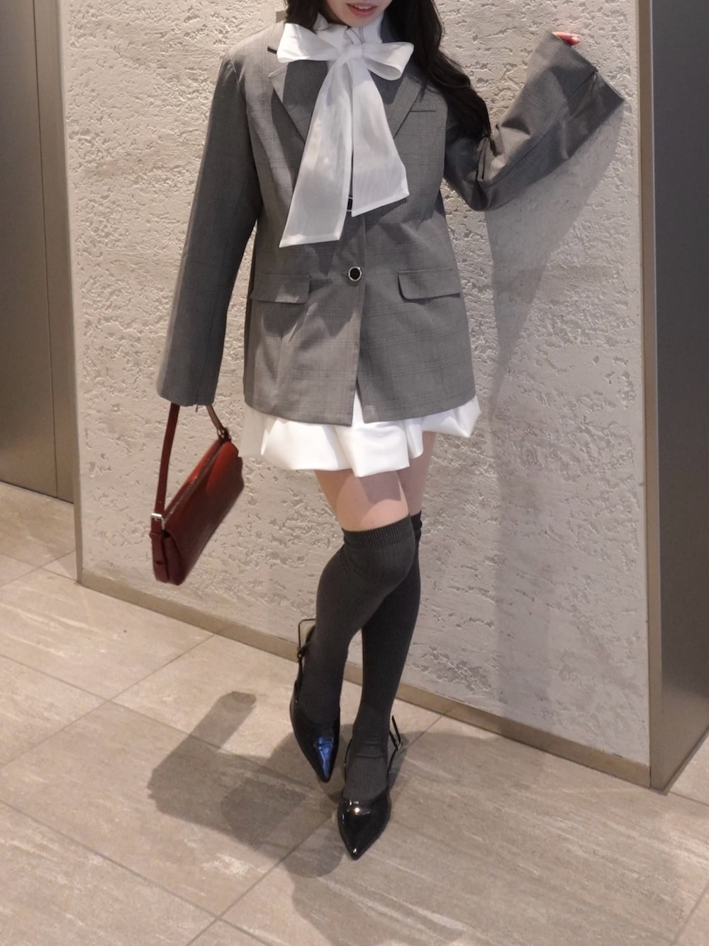 グレー系のテーラードジャケット、その他のシャツ/ブラウス、ホワイト系のスカートを着用したレディースの冬コーディネートの4枚目の写真