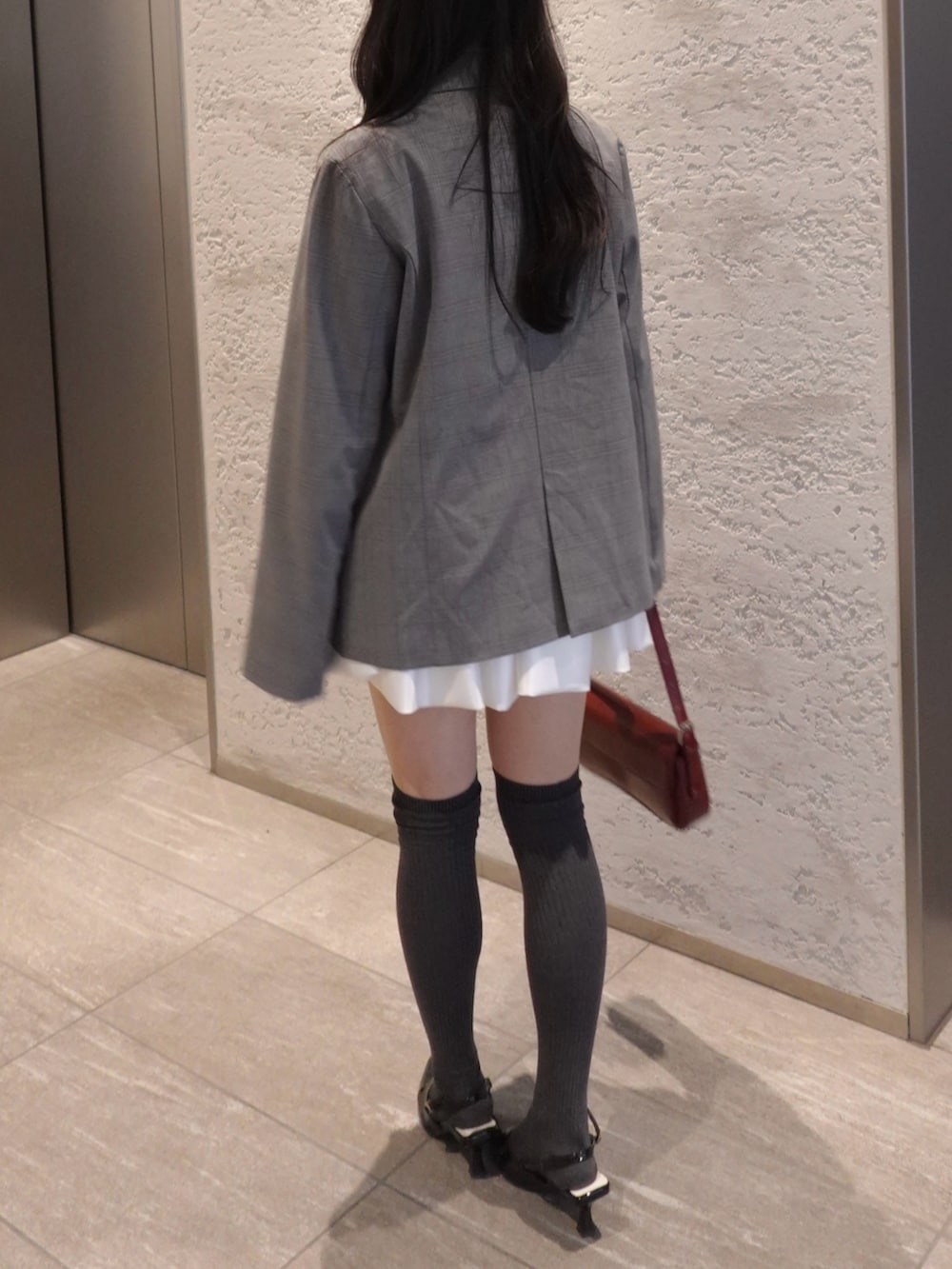 グレー系のテーラードジャケット、その他のシャツ/ブラウス、ホワイト系のスカートを着用したレディースの冬コーディネートの3枚目の写真