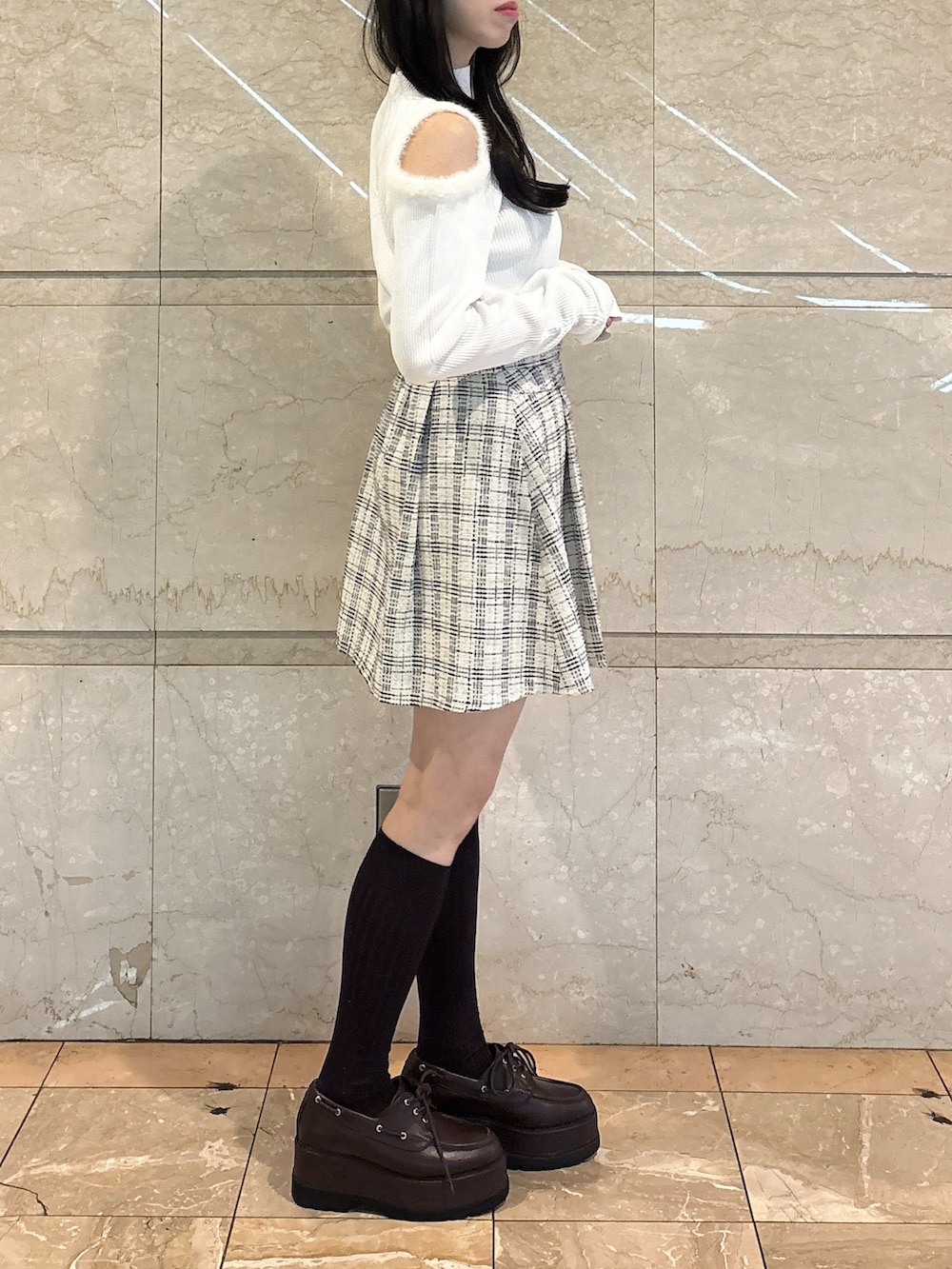 ホワイト系のニット/セーター、ホワイト系のスカート、ブラウン系のローファーを着用したレディースの冬コーディネートの5枚目の写真