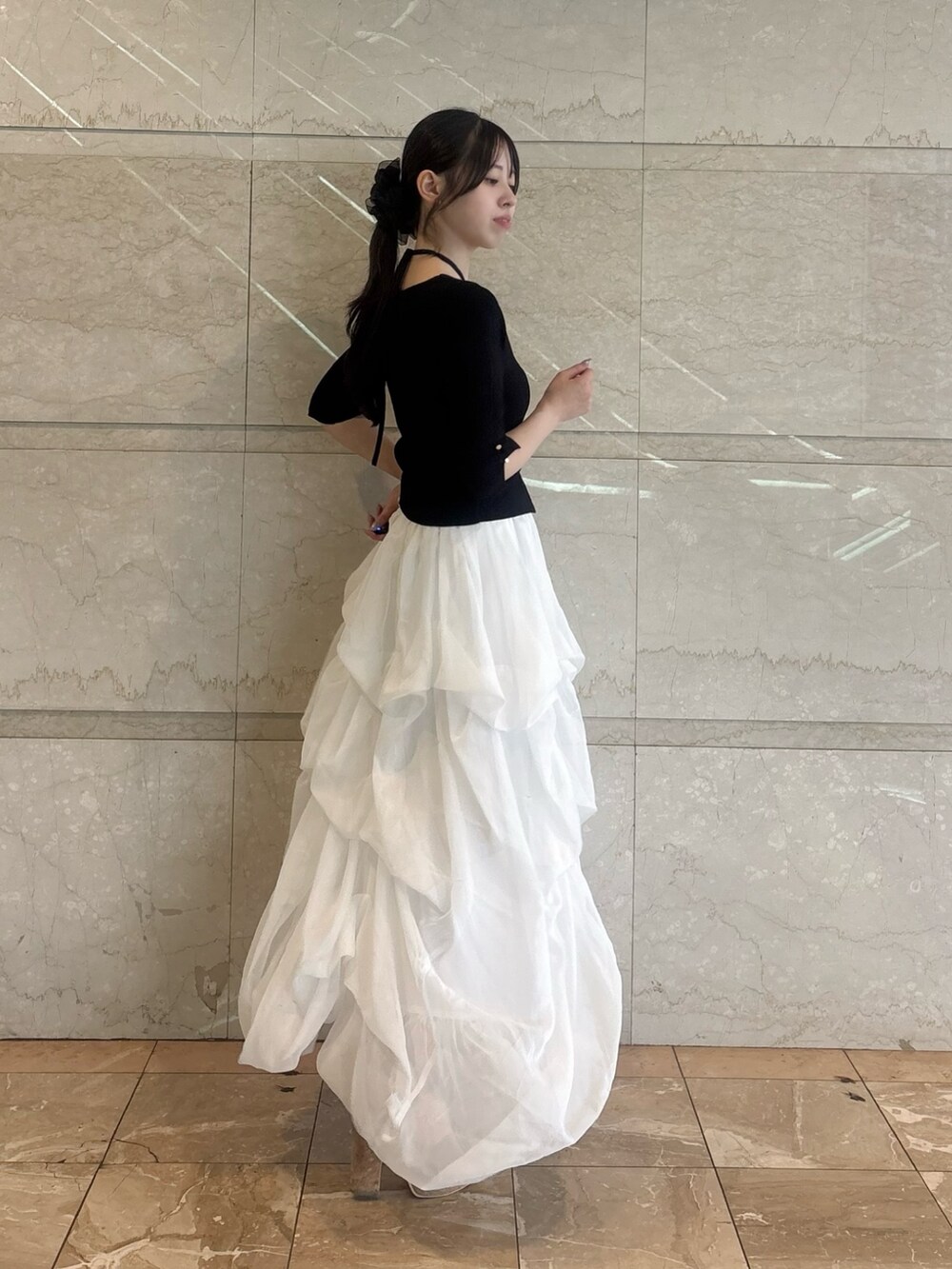 ブラック系のニット/セーター、ホワイト系のスカートを着用したレディースの夏コーディネートの2枚目の写真