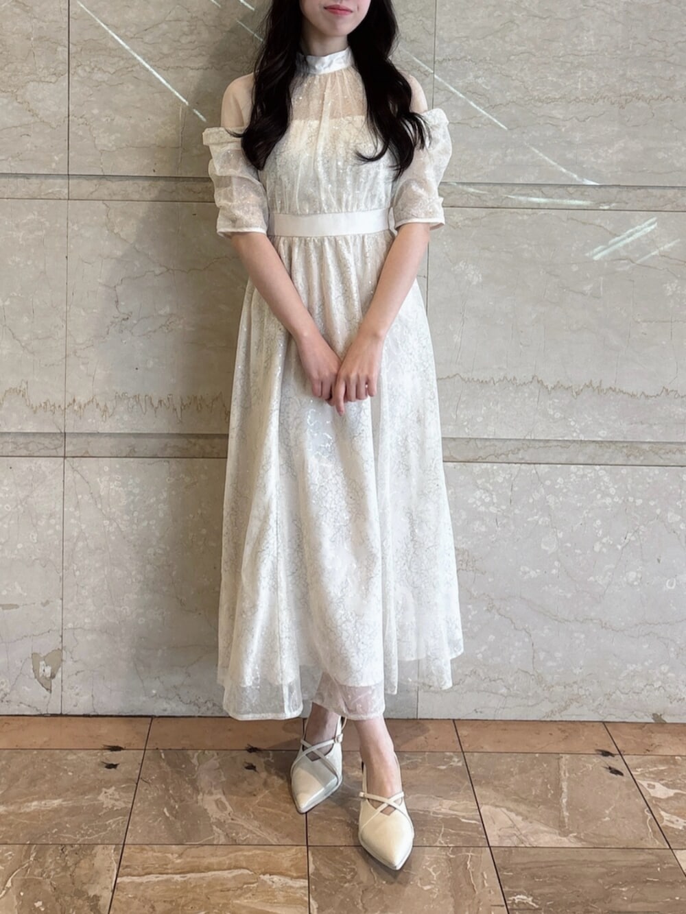 ホワイト系のパンプス、ホワイト系のドレスを着用したレディースの冬コーディネートの5枚目の写真