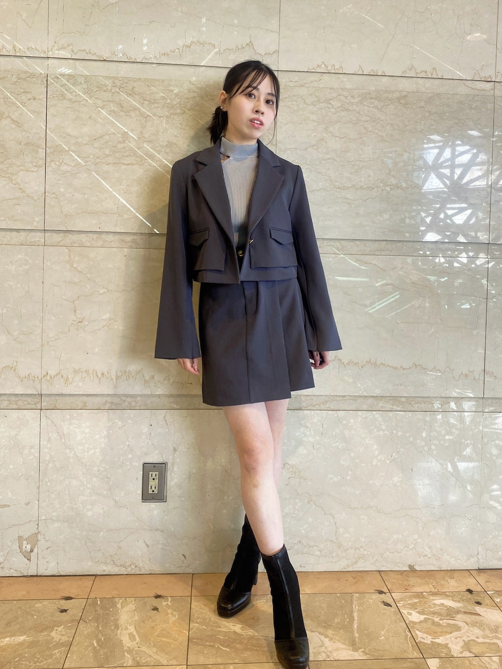グレー系のテーラードジャケット、グレー系のスカート、グレー系のニット/セーターを着用したレディースの春コーディネートの3枚目の写真