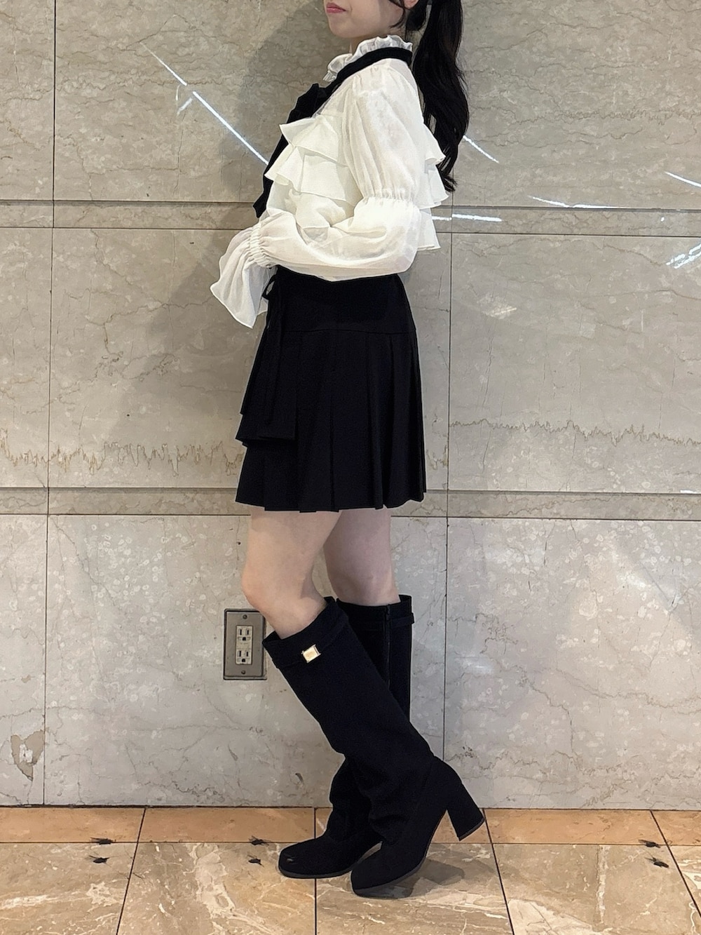 ホワイト系のシャツ/ブラウス、ブラック系のスカート、ブラック系のブーツを着用したレディースの秋コーディネートの2枚目の写真