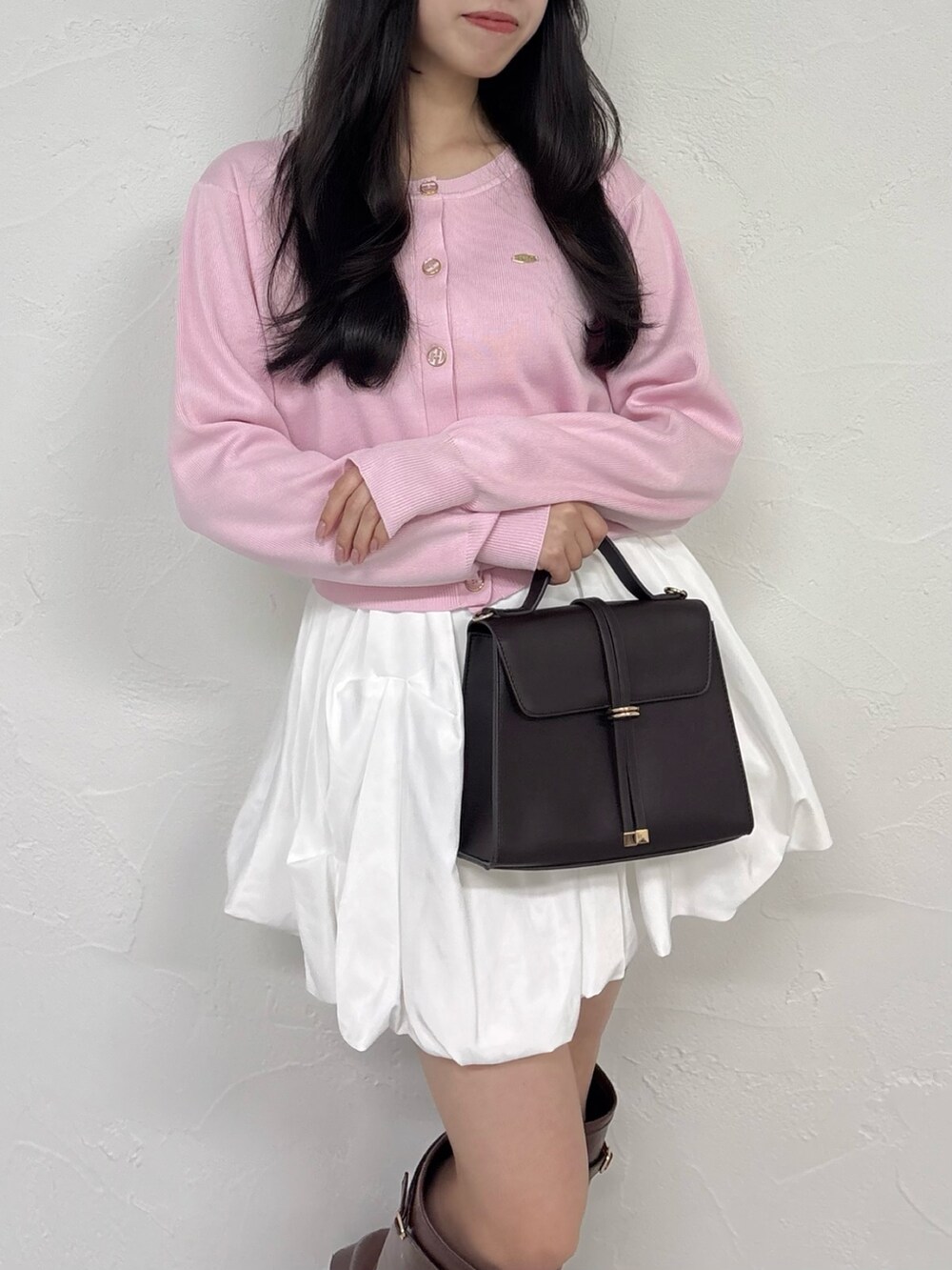 ピンク系のカーディガン/ボレロ、ホワイト系のスカート、ブラウン系のブーツを着用したレディースの秋コーディネートの6枚目の写真