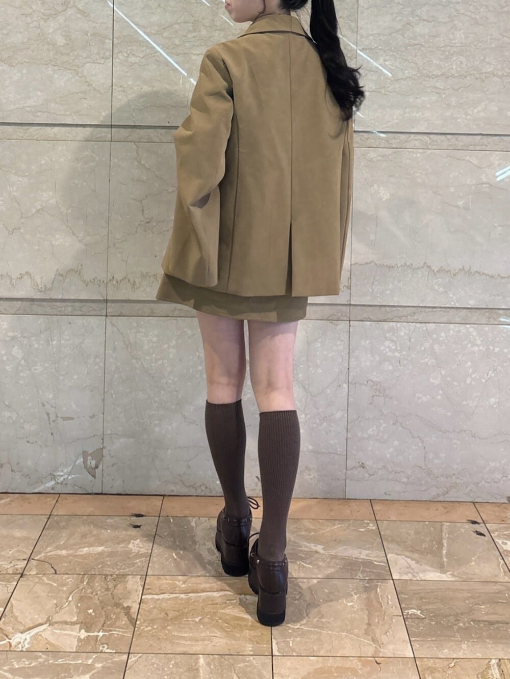 ブラウン系のローファー、ホワイト系のシャツ/ブラウス、ベージュ系のテーラードジャケットを着用したレディースの冬コーディネートの4枚目の写真