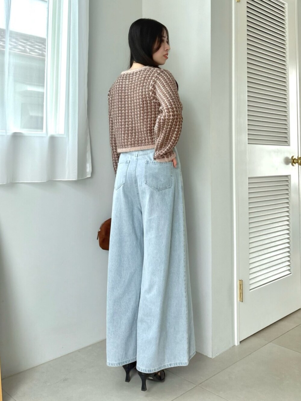 ブルー系のデニムパンツ、ブラウン系のカーディガン/ボレロを着用したレディースの秋コーディネートの5枚目の写真