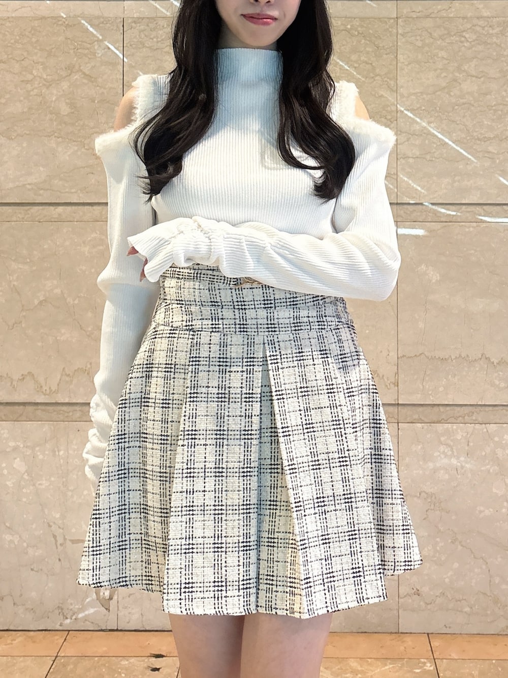 ホワイト系のニット/セーター、ホワイト系のスカート、ブラウン系のローファーを着用したレディースの冬コーディネートの7枚目の写真