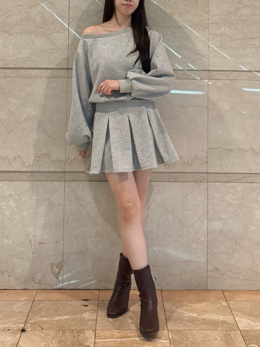 ブラウン系のブーツ、グレー系のスウェット、グレー系のスカートを着用したレディースの秋コーディネートの2枚目の写真