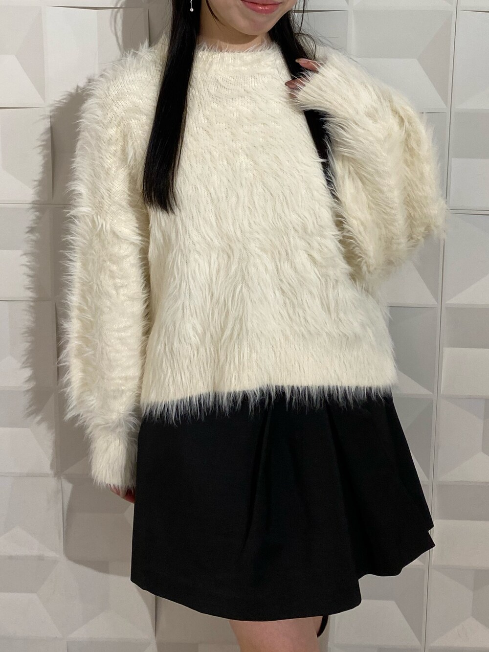 ホワイト系のニット/セーター、ブラック系のスカートを着用したレディースの秋コーディネートの6枚目の写真