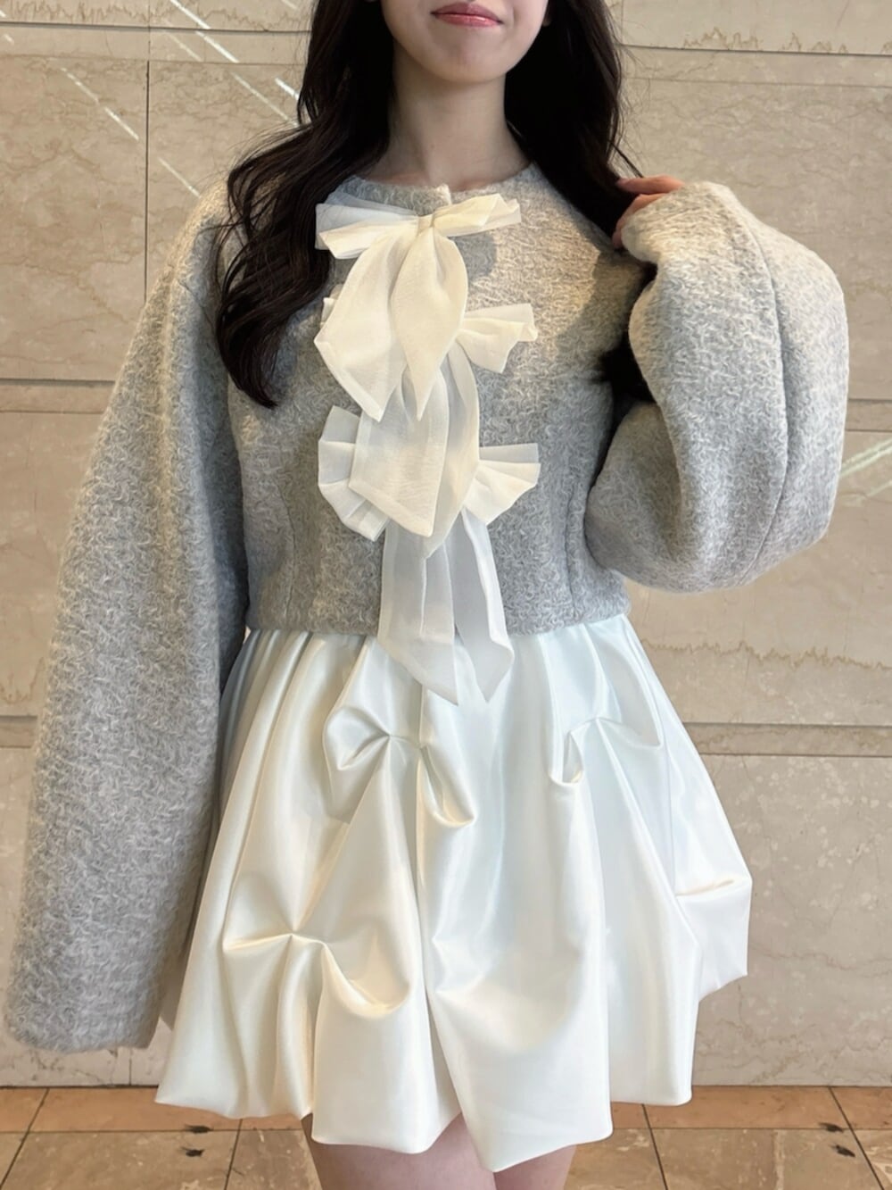 ブラウン系のローファー、グレー系のブルゾン、ホワイト系のスカートを着用したレディースの冬コーディネートの7枚目の写真