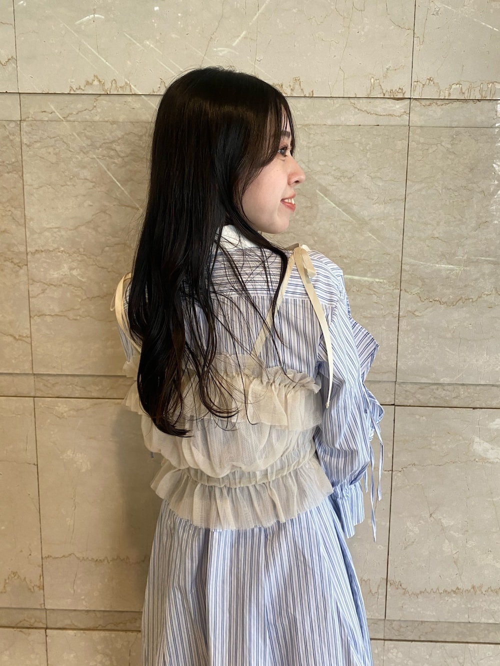 ブルー系のシャツワンピース、ホワイト系のハンドバッグを着用したレディースの夏コーディネートの8枚目の写真