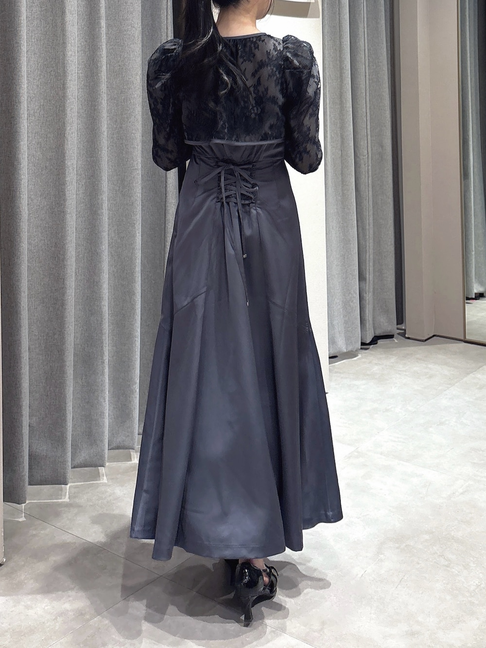 ブラック系のドレス、ブラック系のパンプスを着用したレディースの冬コーディネートの7枚目の写真