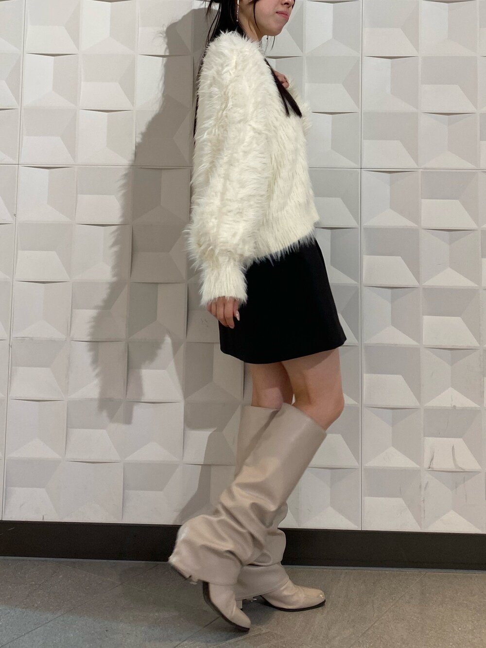 ホワイト系のニット/セーター、ブラック系のスカートを着用したレディースの秋コーディネートの4枚目の写真