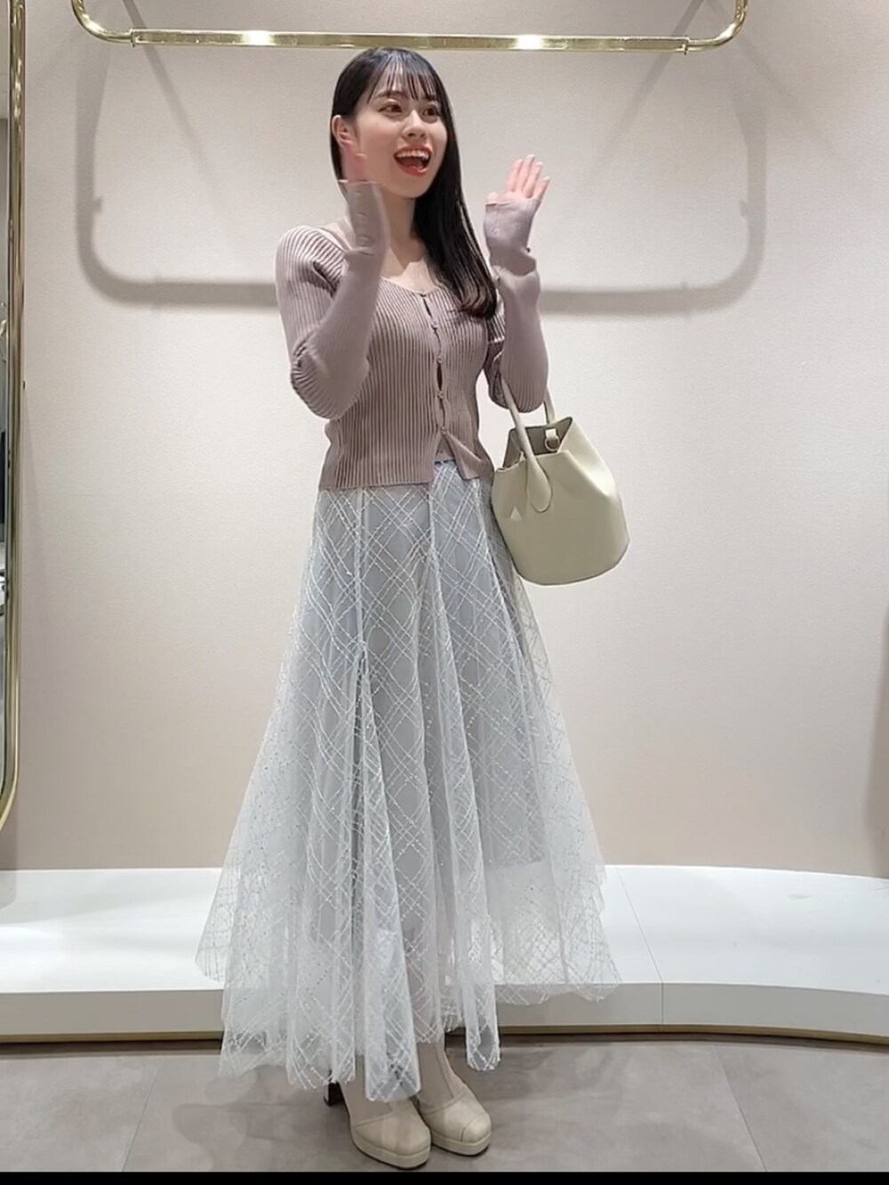 ピンク系のニット/セーター、グレー系のスカートを着用したレディースの冬コーディネートの3枚目の写真