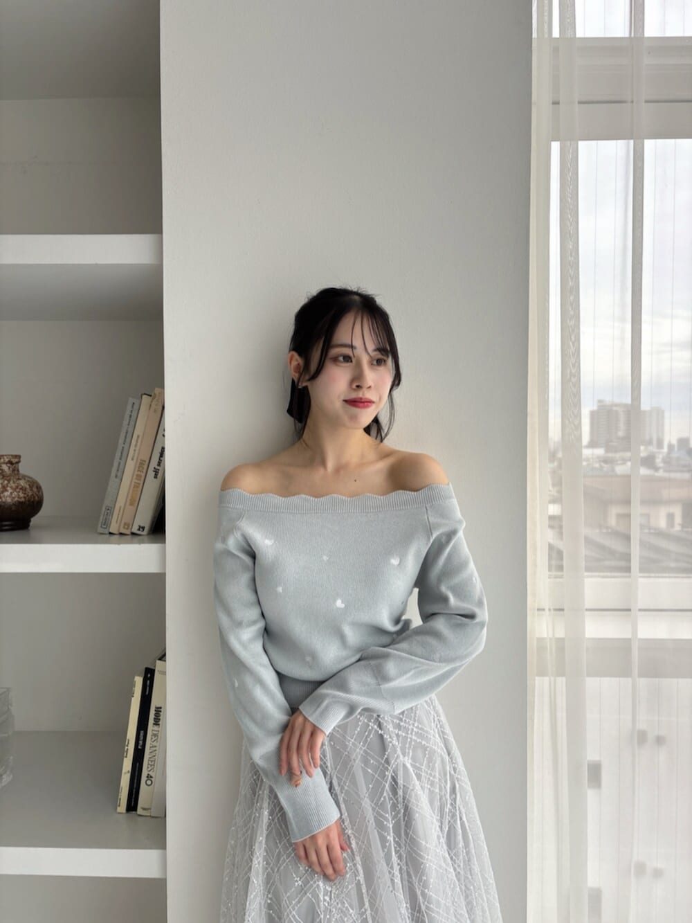 ホワイト系のパンプス、グリーン系のニット/セーター、グレー系のスカートを着用したレディースの冬コーディネートの8枚目の写真