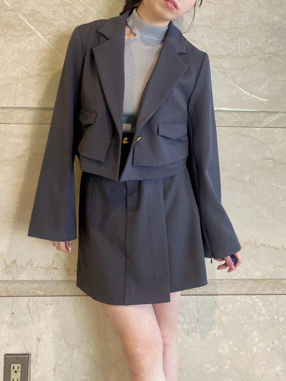 グレー系のテーラードジャケット、グレー系のスカート、グレー系のニット/セーターを着用したレディースの春コーディネートの4枚目の写真