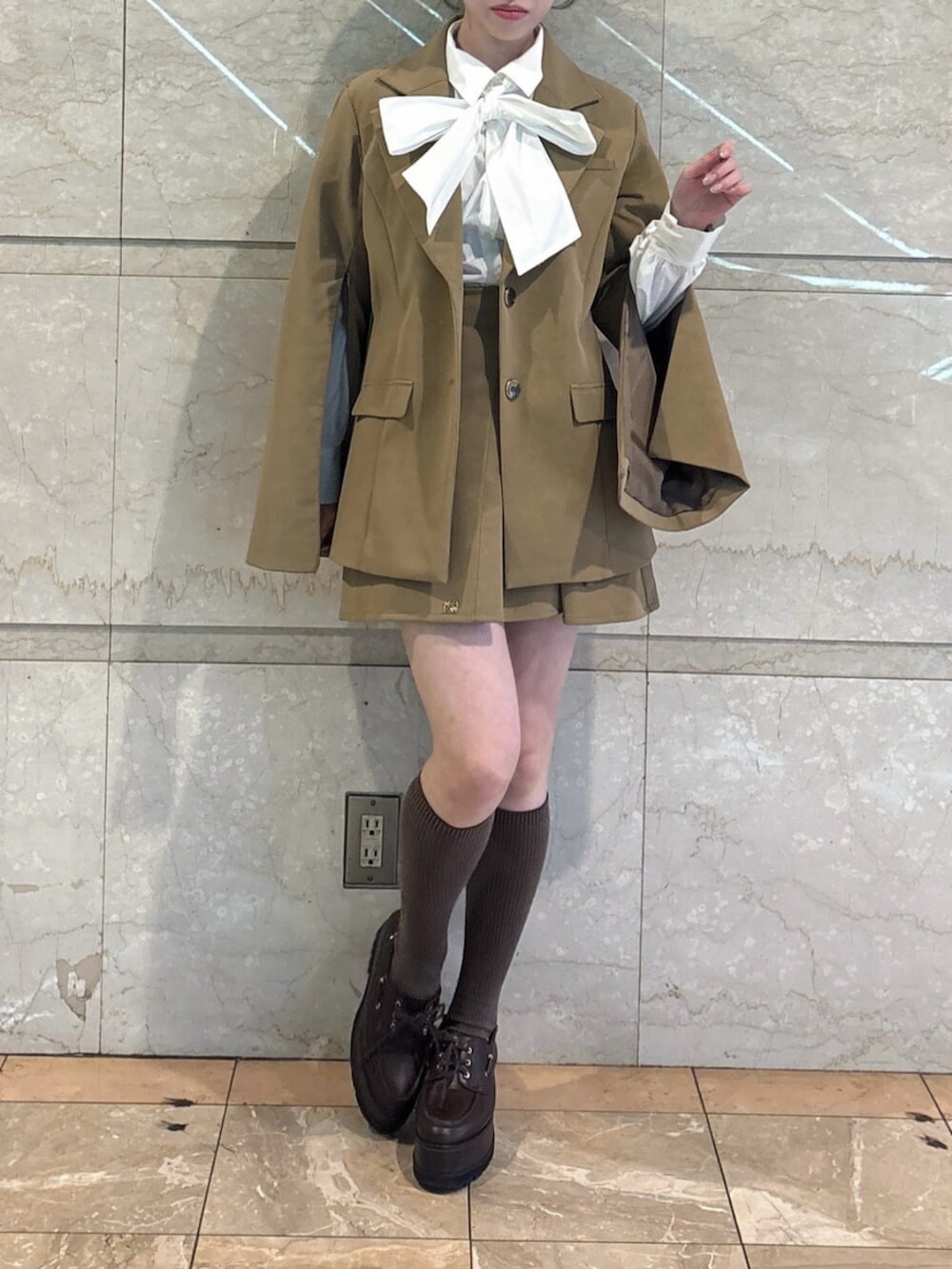 ブラウン系のローファー、ホワイト系のシャツ/ブラウス、ベージュ系のテーラードジャケットを着用したレディースの冬コーディネートの2枚目の写真