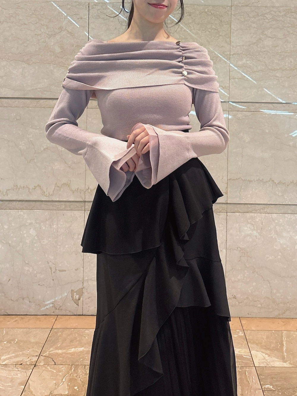 ブラック系のスカート、ピンク系のニット/セーター、ブラック系のブーツを着用したレディースの冬コーディネートの9枚目の写真