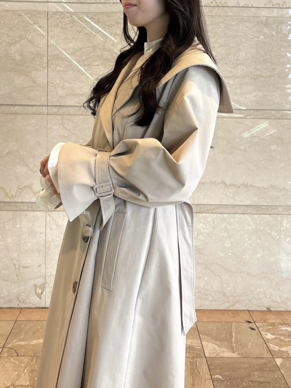 ホワイト系のパンプス、ベージュ系のトレンチコートを着用したレディースの冬コーディネートの8枚目の写真