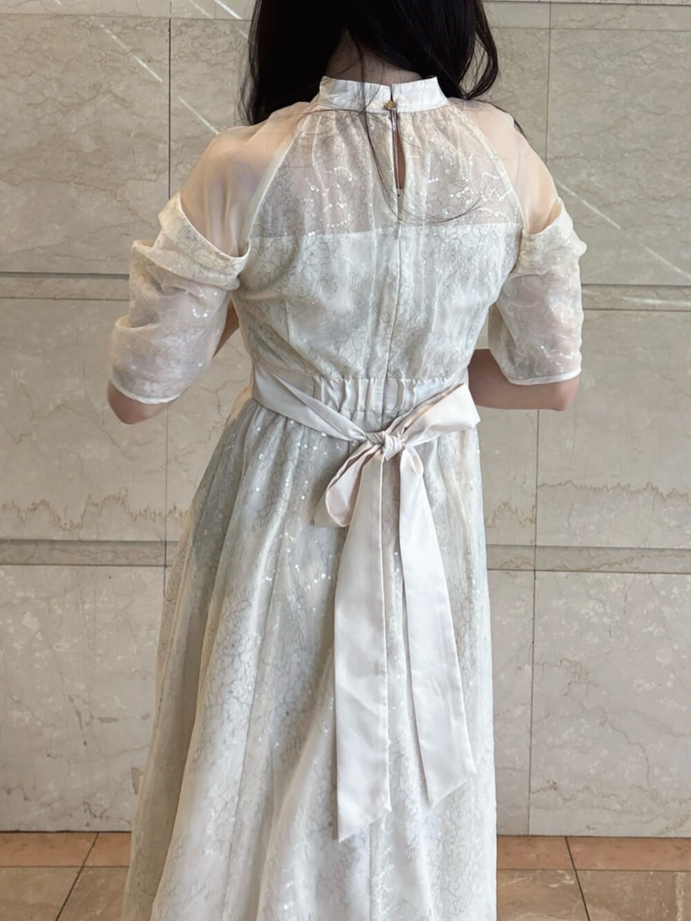 ホワイト系のパンプス、ホワイト系のドレスを着用したレディースの冬コーディネートの9枚目の写真