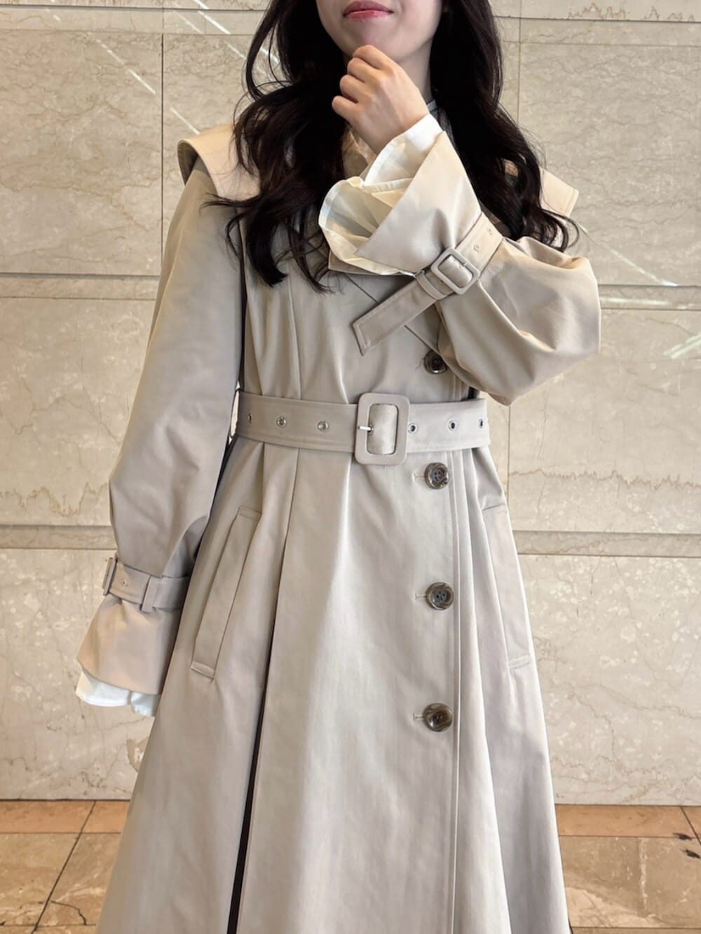 ホワイト系のパンプス、ベージュ系のトレンチコートを着用したレディースの冬コーディネートの6枚目の写真