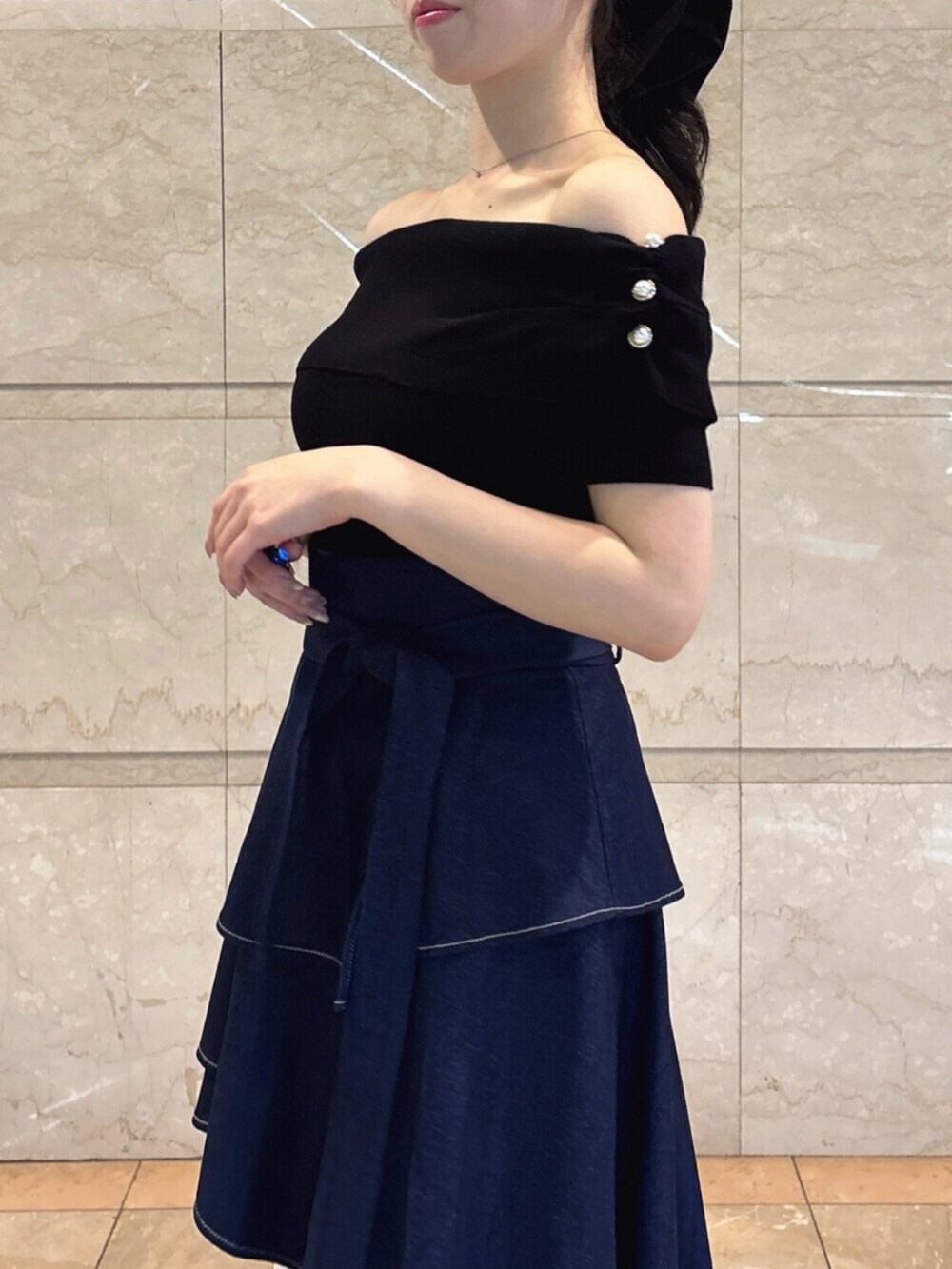ホワイト系のパンプス、ブルー系のスカート、ブラック系のニット/セーターを着用したレディースの春コーディネートの7枚目の写真