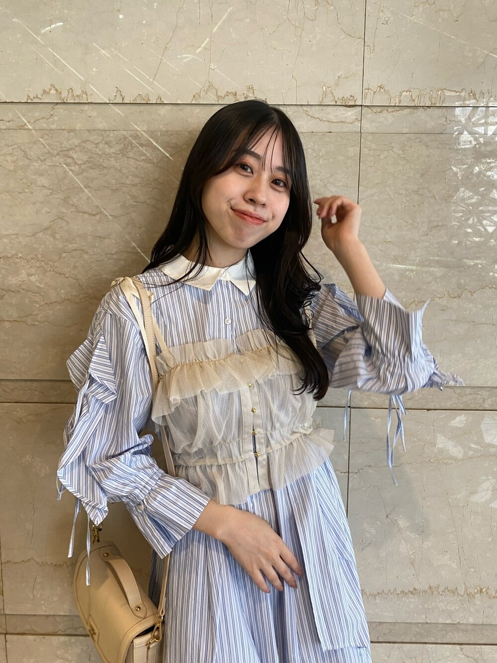 ブルー系のシャツワンピース、ホワイト系のハンドバッグを着用したレディースの夏コーディネートの7枚目の写真