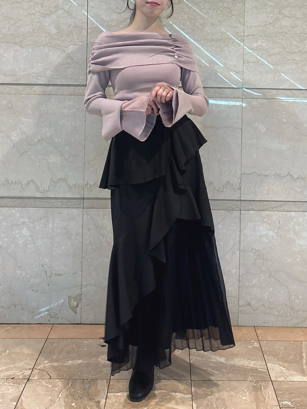 ブラック系のスカート、ピンク系のニット/セーター、ブラック系のブーツを着用したレディースの冬コーディネートの3枚目の写真