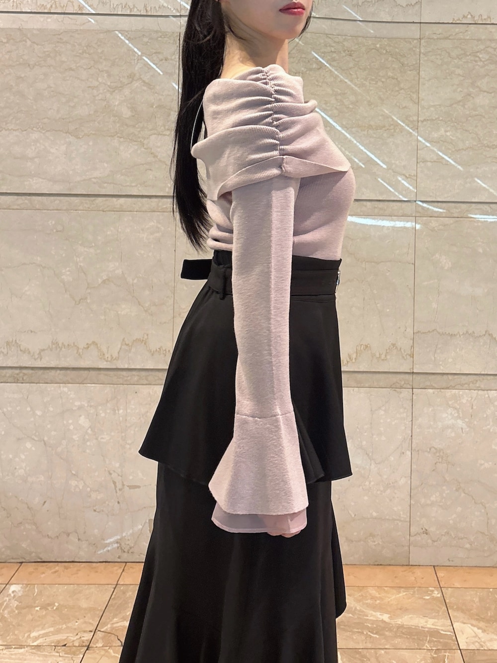 ブラック系のスカート、ピンク系のニット/セーター、ブラック系のブーツを着用したレディースの冬コーディネートの8枚目の写真